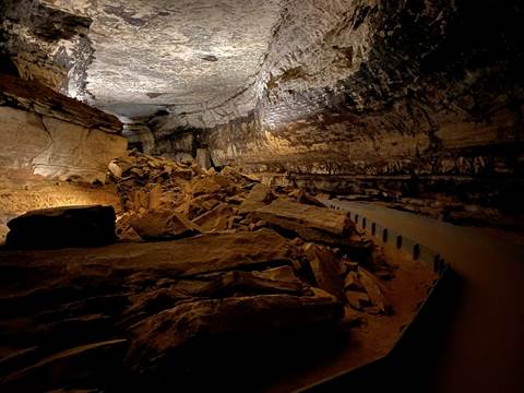 A large cave passage with a paved trail on the right side.