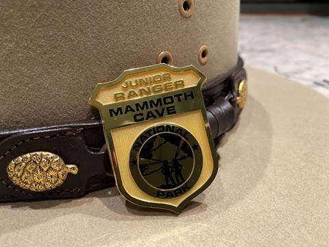 A plastic junior ranger badge sitting on a ranger hat