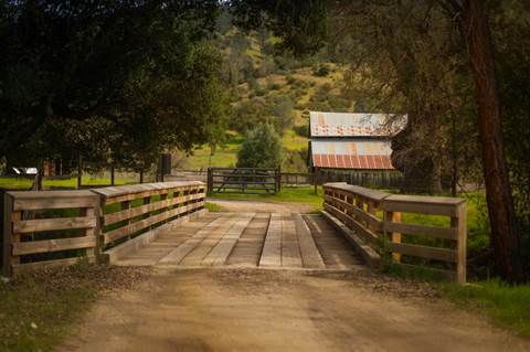 Wooden bridge entry to small ranch.